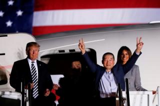 One of the Americans formerly held hostage in North Korea gestures next to US President Donald Trump and first lady Melania Trump, upon their arrival at Joint Base Andrews, Maryland