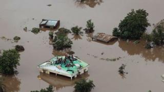 Abantu buriye hejuru ku mazu no ku biti kugira barokore ubuzima mu gisagara ca Beira muri Mozambique