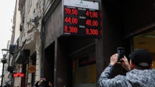Hombre toma foto a casa de cambio en Argentina.