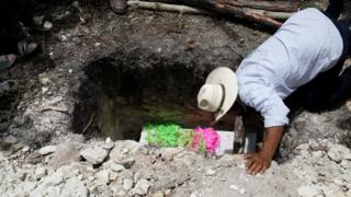 Wilmer Josué Ramírez's coffin being buried in the ground