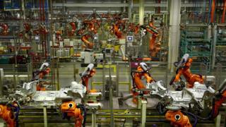 ABB robotic arms work on the body parts of Mini cars as they pass along a section of automated production line at the BMW Mini car production plant in Oxford.