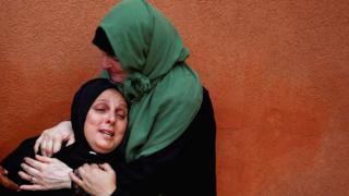 Palestinians mourn during the funeral of nurse Haniyeh Qudih, who was killed in an Israeli strike