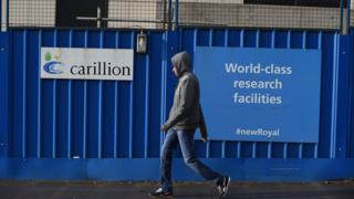 Человек проходит мимо строительной площадки Carillion