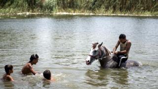 Egyptians cool off near Cairo at Ain Al Sera lake in Al Fostat district, Cairo, Egypt - Friday 22 June 2018