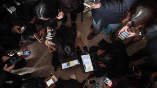 Grupa ljudi kuca na mobilnim telefonima i tabletima
