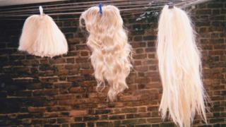 Three wigs on a washing line