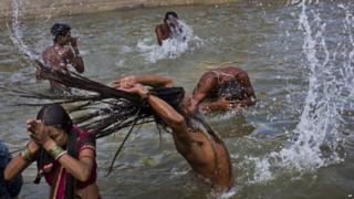 Индуистские преданные принимают ванну в реке Годавари во время Кумбха-мела, или Праздник кувшина, в Насике, Индия, 29 августа 2015 года