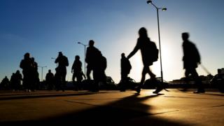 Pessoas caminham em rua movimentada