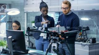 Man and woman work on drone project