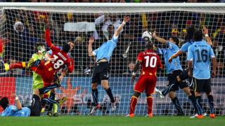 Suárez despeja con la mano el balón para evitar el tanto de Ghana