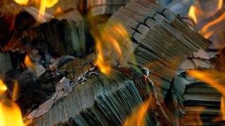 Billetes quemándose en el fuego