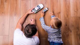 Padre e hijo juegan con coches de juguete