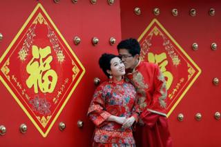 Пара, одетая в традиционные китайские костюмы, имеет свадебные портреты, сделанные в День святого Валентина 14 февраля 2013 года в Пекине, Китай.