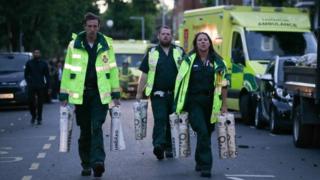 Paramedics carrying oxygen cylinders