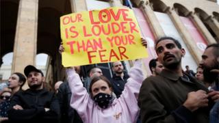 "Nuestro amor suena más fuerte que tu miedo", dice el cartel de una manifestante frente al Parlamento de Georgia el pasado 12 de mayo.