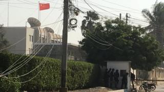 Paramilitary forces and a police officer are hiding behind a wall during an attack on the Chinese Embassy, ​​where gunfire was heard in Karachi, Pakistan on November 23, 2018.