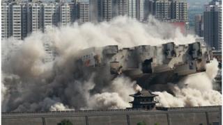 8月8日,山西大同,当地政府对位于北城墙武定西门外的一座90米高的大楼实施爆破拆除,飞扬的尘土与古城墙呼应形成壮观场面。