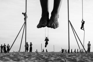 People perform acrobatics on the beach