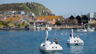 People in a boating lake by the seafront in Hastings