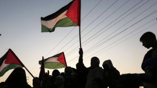 متظاهرون يحملون العلم الفلسطيني في غزة