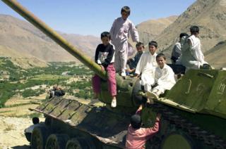 Afghan children play on the turret of an abandoned Soviet tank in the Panjshir valley , 2003