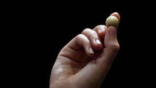 A pupil from San Ildefonso school holds the winning number 26590, that represents takings of 4 million (Â£2.9 million) euros, during the draw of Spain"s Christmas lottery "El Gordo" (the Fat One) at the Royal Theatre in Madrid