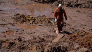 Bombeiro procura por sobreviventes após rompimento da barragem em Brumadinho
