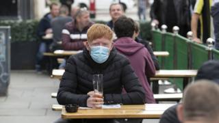A man enjoying a drink at a table outside a pub in Glasgow, Scotland