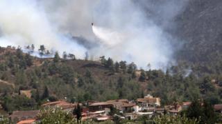 A helicopter drops water on a forest fire in the village of Eyrixou in the Troodos mountain area, Cyprus, 20 June 2016.