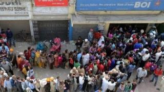 লোকজন দীর্ঘ লাইনে দাঁড়িয়েছেন ব্যাঙ্কের সামনে নোট জমা দিতে