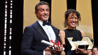 La cinéaste franco-sénégalaise Mati Diop, lauréate du Grand Prix du 72ème Festival de Cannes, le 25 mai 2019, pose avec l'acteur et réalisateur américain Sylvester Stallone.