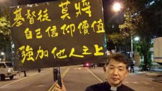 陳思豪牧師舉牌,上面寫到:基督徒莫將信仰價值強加他人之上