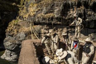 The thick ropes are tied to the stone supports