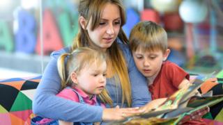 Au pair reading to two children