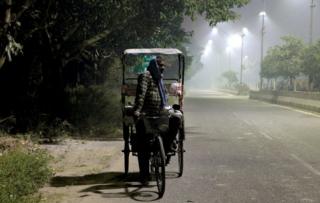 A rickshaw puller in smog