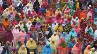 This photo taken on August 21, 2018 shows Indian women welcoming the Eid al-Adha festival with prayers near a shrine complex in Ahmedabad. - Muslims are celebrating Eid al-Adha (the feast of sacrifice), the second of two Islamic holidays celebrated worldwide marking the end of the annual pilgrimage or Hajj to the Saudi holy city of Mecca.