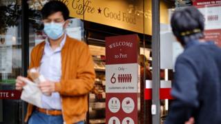 Person walks out of Pret with a baguette