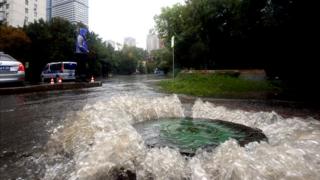 Вода, бурлящая у люка на московской улице