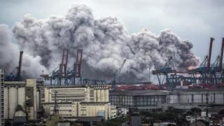 A general view over the port on a giant cloud of smoke billowing in Guaruja, near Santos, Sao Paulo, Brazil, 14 January 2016. According to reports, the smoke was caused by a chemical reaction of Dichloroisocyanuric acid in contact with water that entered a cargo container. EPA