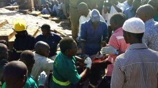 Survivor carried out on a stretcher as crowds look on