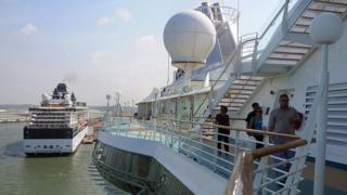 Tourists walk on deck of a cruise ship anchored in Colon, some 100 km north of Panama City on December 7, 2008.