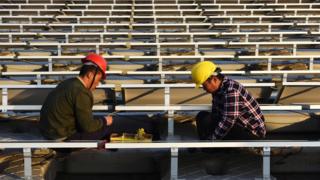 Мужчины в касках работают на солнечной электростанции в Китае