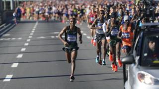 Shura Kitata, left, and Lelisa Desisa, right, run.