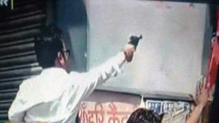 A man believed to be Raja Chauhan pointing his pistol in a photo that has gone viral