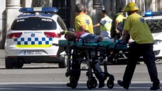 Police officers and emergency service workers move an injured man, after a van crashes into pedestrians in Las Ramblas, downtown Barcelona, Spain, 17 August 2017