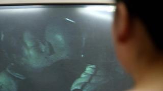 A detective from the Women's Rights Protection Investigation Center shows off a video they shot of a cheating husband with his mistress, in Chengdu.