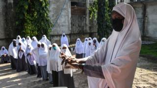 A student washes her hands as they attend their first day of re-opened school in Dar es Salaam, Tanzania, on June 1, 2020.