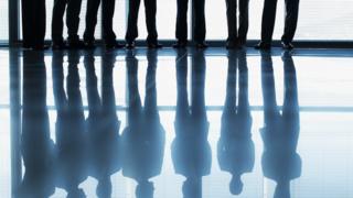 Stock image of people in suits silhouetted