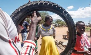 Residents look on as they reflect after seeing a swarm of locusts pass through Lopei in Uganda on 16 February 2020.