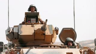 Turkish soldiers with tanks return from Syria to Turkey after a military operation at the Syrian border as part of their offensive against the Islamic State (IS) militant group